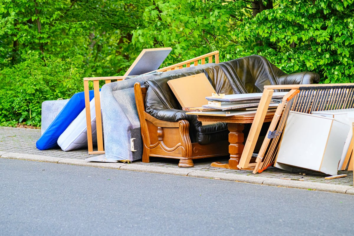 Discarded furniture and mattresses piled up on the curb for collection